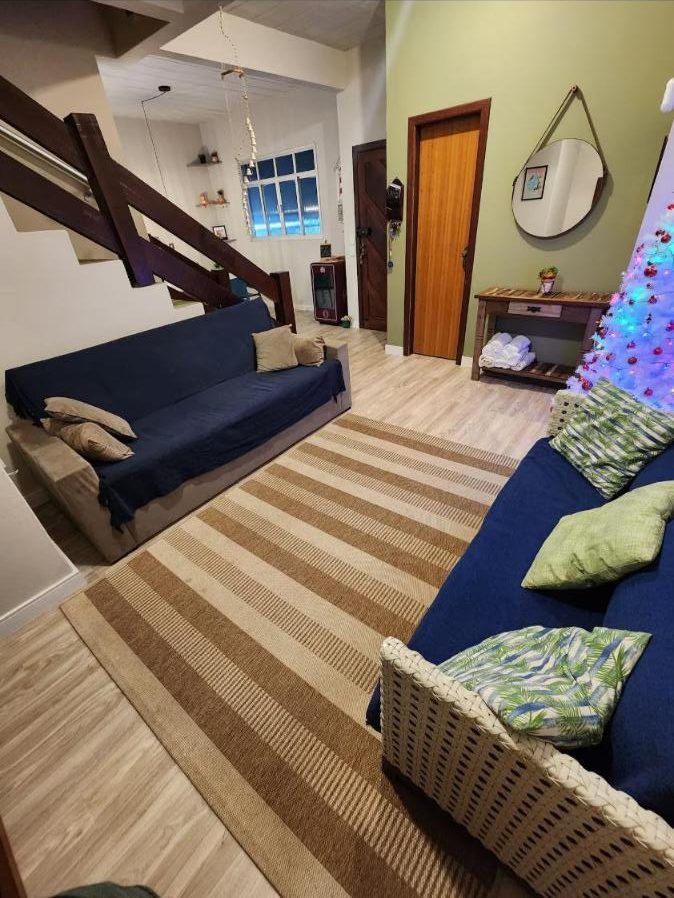 Sala com dois sofás e escada para o andar de cima